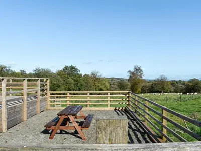a wooden bench sitting next to a fence at Cartws Blaenparc Coach House - Uk41031 in Mydroilin