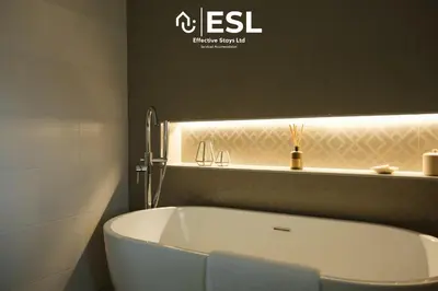 a white bath tub in a bathroom with a sink at Large Country Farmhouse, Shropshire Hills View, with Hot Tub in Minsterley