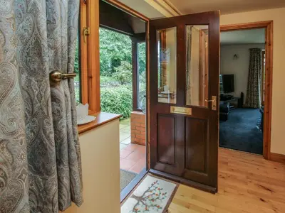 an open door to a living room with a glass door at Rowan Cottage in Shrewsbury