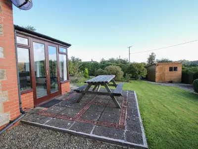 a picnic table in the backyard of a house at Rowan Cottage in Shrewsbury