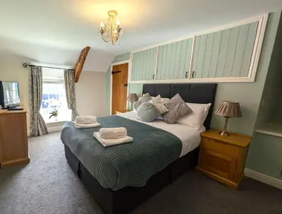a bedroom with a large bed with towels on it at Penuwch Fach in Aberystwyth