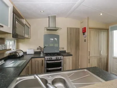 a kitchen with a sink and a stove top oven at Mallard in Leominster
