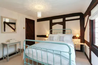 a bedroom with a bed with a blue metal frame at 12A College Hill by Sleep Shrewsbury in Shrewsbury