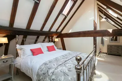 a bedroom with a large bed with red pillows at 12A College Hill by Sleep Shrewsbury in Shrewsbury
