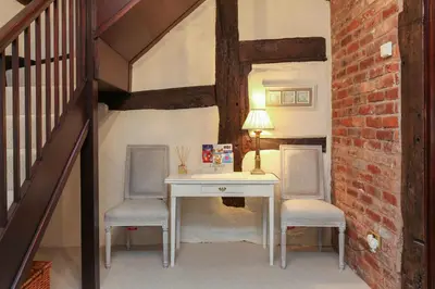 a desk with two chairs and a lamp in a room at 12A College Hill by Sleep Shrewsbury in Shrewsbury