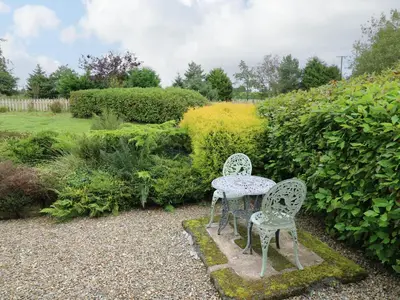 two chairs and a table in a garden at Rhydygroes in Lampeter