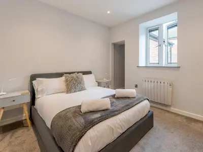 a bedroom with a bed with a desk and a window at 5A One Bedroom Modern Town Centre Apartment - Pass the Keys in Shrewsbury