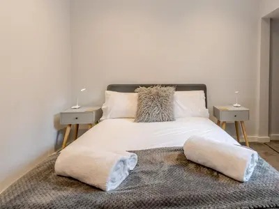 a bedroom with a white bed with two night stands at 5A One Bedroom Modern Town Centre Apartment - Pass the Keys in Shrewsbury