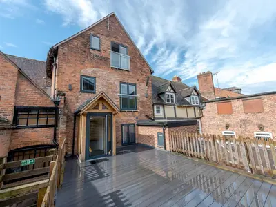 an empty deck in front of a brick building at 5A One Bedroom Modern Town Centre Apartment - Pass the Keys in Shrewsbury