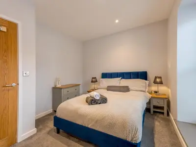 a bedroom with a blue bed and two night stands at 5B One bedrom Central Modern Apartment - Pass the Keys in Shrewsbury