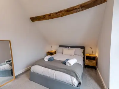 a bedroom with a bed and a mirror at 5C Charming Town Centre Apartment With Roof Top Views - Pass the Keys in Shrewsbury
