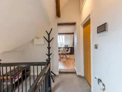 a staircase leading to a living room and a dining room at 5C Charming Town Centre Apartment With Roof Top Views - Pass the Keys in Shrewsbury