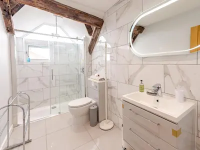a bathroom with a shower and a toilet and a sink at 5C Charming Town Centre Apartment With Roof Top Views - Pass the Keys in Shrewsbury
