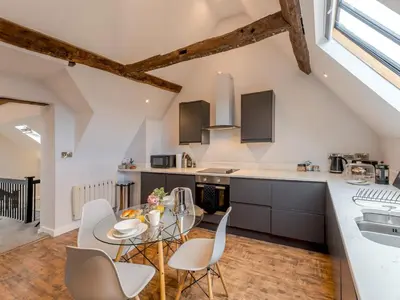 a kitchen with a glass table and white chairs at 5C Charming Town Centre Apartment With Roof Top Views - Pass the Keys in Shrewsbury