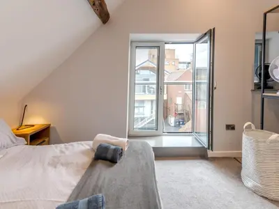 a bedroom with a bed and a large window at 5C Charming Town Centre Apartment With Roof Top Views - Pass the Keys in Shrewsbury