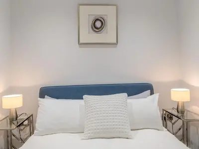 a white bed with two lamps on either side of it at 40C 2 bed Celosia Beautiful Town Centre Apartment - Pass the Keys in Shrewsbury