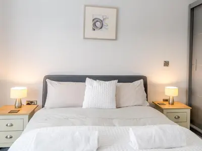 a bedroom with a white bed with two night stands at 40C 2 bed Celosia Beautiful Town Centre Apartment - Pass the Keys in Shrewsbury