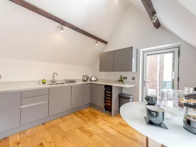 a kitchen with white cabinets and a table at 1 bed 40C Beautiful Town Apartment Celosia - Pass the Keys in Shrewsbury