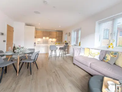 a living room and kitchen with a couch and a table at Contemporary Apartment with Secure Parking - Pass the Keys in Shrewsbury