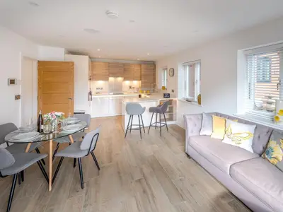 a living room and kitchen with a couch and a table at Contemporary Apartment with Secure Parking - Pass the Keys in Shrewsbury