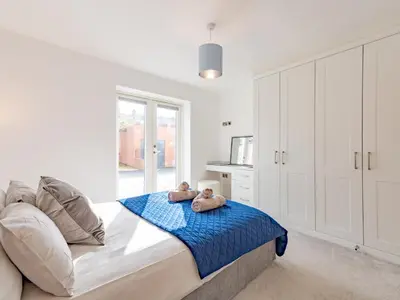 two teddy bears sitting on a bed in a bedroom at Contemporary Apartment with Secure Parking - Pass the Keys in Shrewsbury