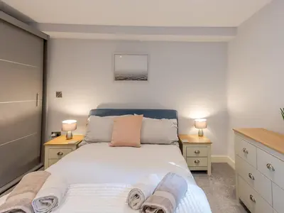 a bedroom with a large bed and two night stands at Amaranth Stylish town centre apartment - Pass the Keys in Shrewsbury