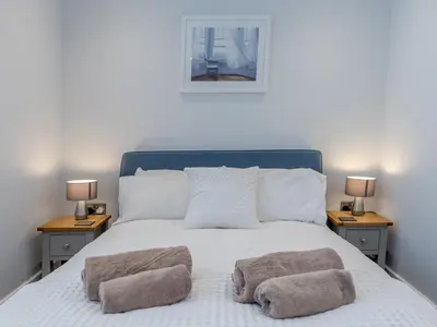 a bedroom with a bed with two nightstands and two lamps at Dahlia Contemporary town centre apartment - Pass the Keys in Shrewsbury