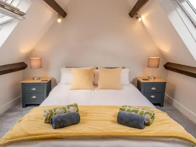 a bedroom with a large bed with two night stands at Dahlia Contemporary town centre apartment - Pass the Keys in Shrewsbury