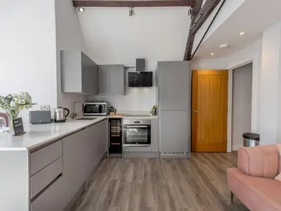 a kitchen with white cabinets and a brown door at 1 bed 40D Dahlia Contemporary town centre apartment - Pass the Keys in Shrewsbury