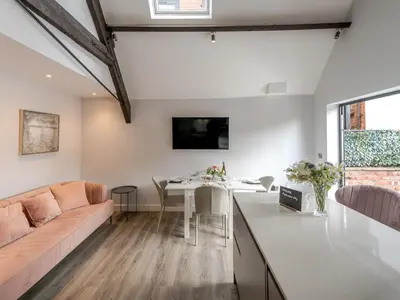 a kitchen and living room with a couch and a table at 1 bed 40D Dahlia Contemporary town centre apartment - Pass the Keys in Shrewsbury
