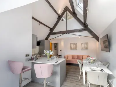 a dining room and living room with a table and chairs at 1 bed 40D Dahlia Contemporary town centre apartment - Pass the Keys in Shrewsbury