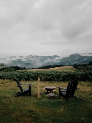 two chairs and a picnic table in a field at Hoku in Llangollen