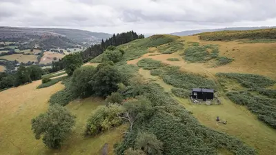 an aerial view of a hill with a barn on it at Hoku in Llangollen