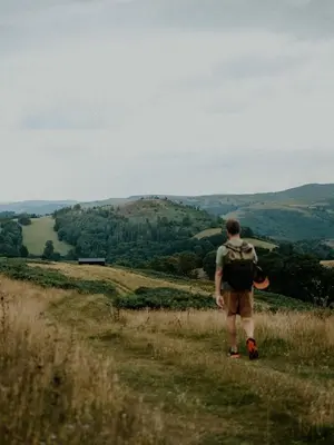 a man walking down a hill with a backpack at Hoku in Llangollen