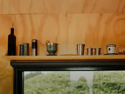 a wooden shelf with cups and a bottle on it at Hoku in Llangollen
