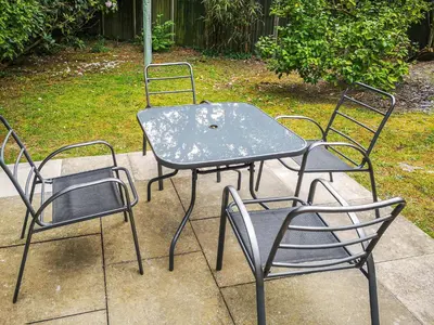 three chairs and a table and a table and chairs at Cysgod Y Coed in Llanbedr