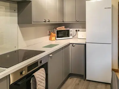 a kitchen with a microwave and a refrigerator at Cysgod Y Coed in Llanbedr