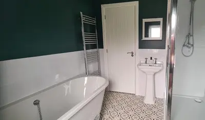 a bathroom with a bath tub and a sink at Cosy yet spacious, 3BR, Parking, Village Location in Oswestry