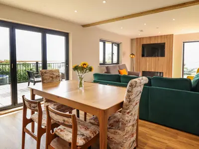 a dining room with a table and a couch at Mynydd Y Glyn Lodge in Llanfyllin