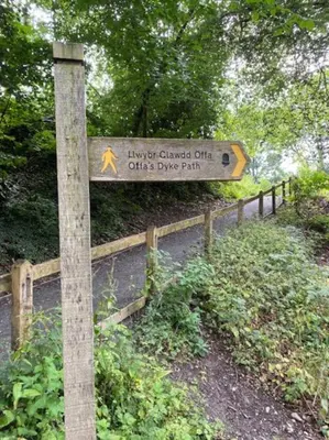 a sign on a wooden pole next to a road at The Garden Room in Knighton