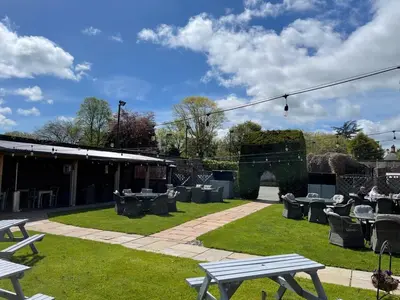 a park with picnic tables and chairs on the grass at Townhouse Apartment in Oswestry