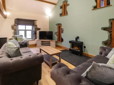 a living room with two couches and a fireplace at The Barn by Lyons in Talybont