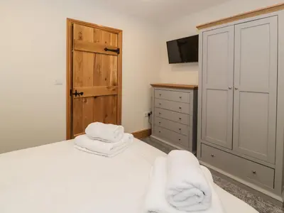 a bedroom with a bed with towels on it at The Barn by Lyons in Talybont