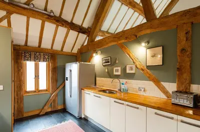 a kitchen with white cabinets and a refrigerator at Meadow End Barn in Dorstone