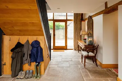 a hallway with a door with a coat hanging on it at Meadow End Barn in Dorstone