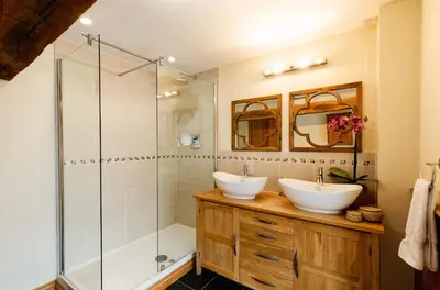a bathroom with two sinks and a shower at Meadow End Barn in Dorstone