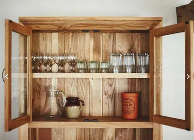 a wooden cabinet with many glasses on it at Dragonfly Cottage, Canal location in Brecon