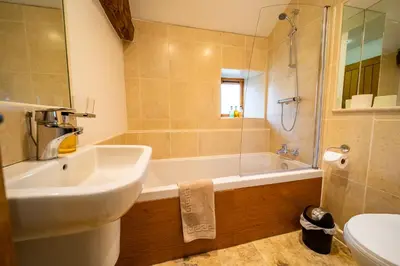 a bathroom with a sink and a tub and a toilet at Dragonfly Cottage, Canal location in Brecon