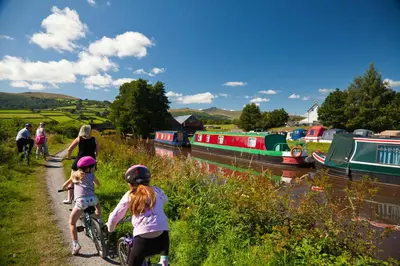 a group of people riding bikes next to a river at Dragonfly Cottage, Canal location in Brecon