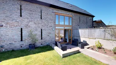 a brick house with a pivoting glass door at Bullrush Barn, Brecon Beacons walkers retreat in Brecon